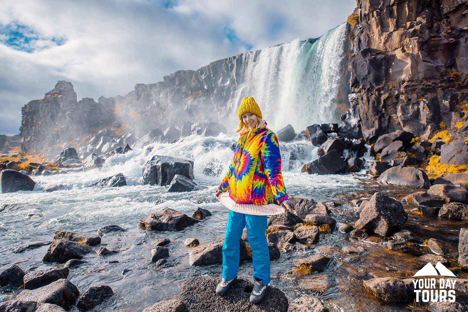happy woman in colourful jacket near oxararfoss