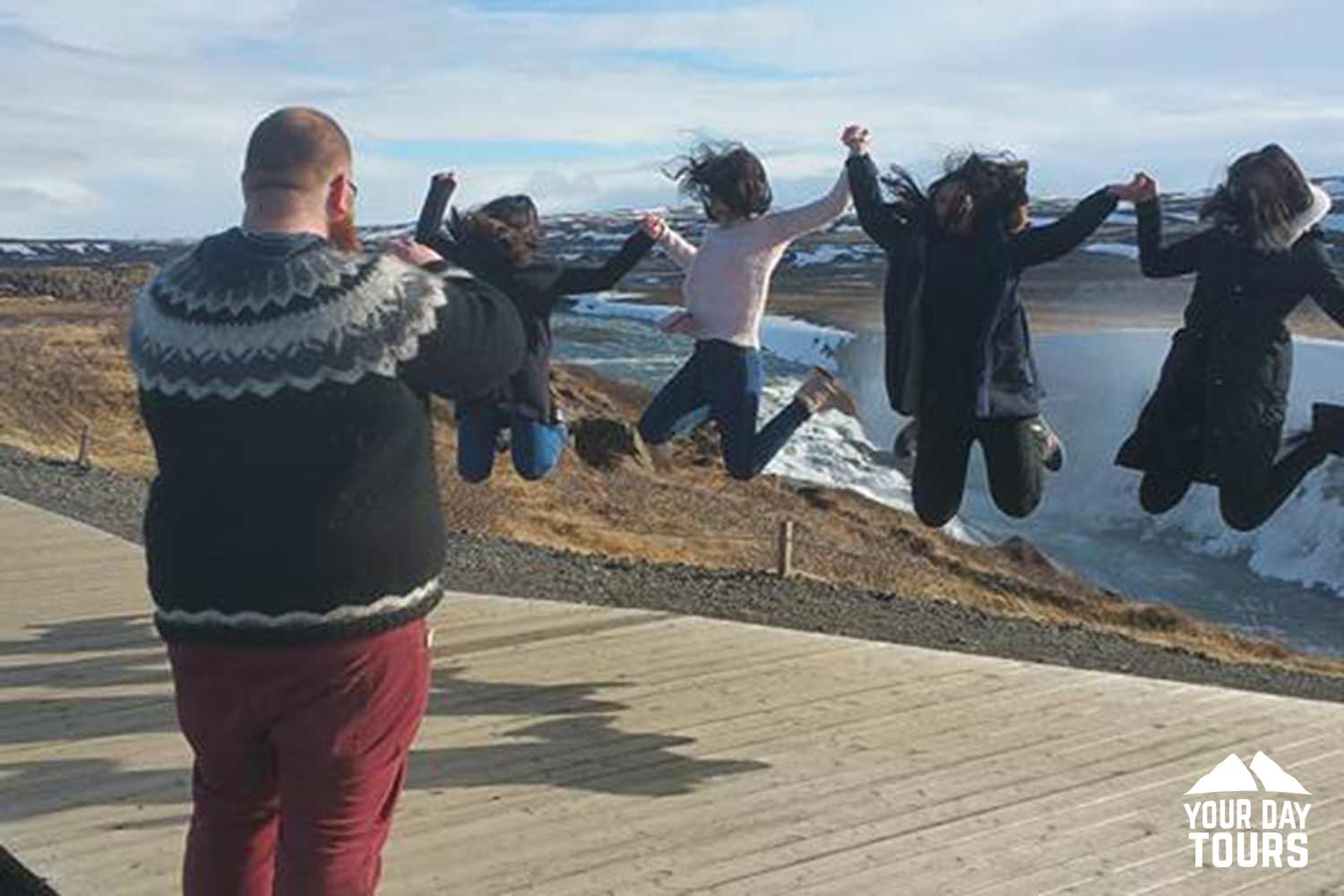 person taking pictures women near gullfoss