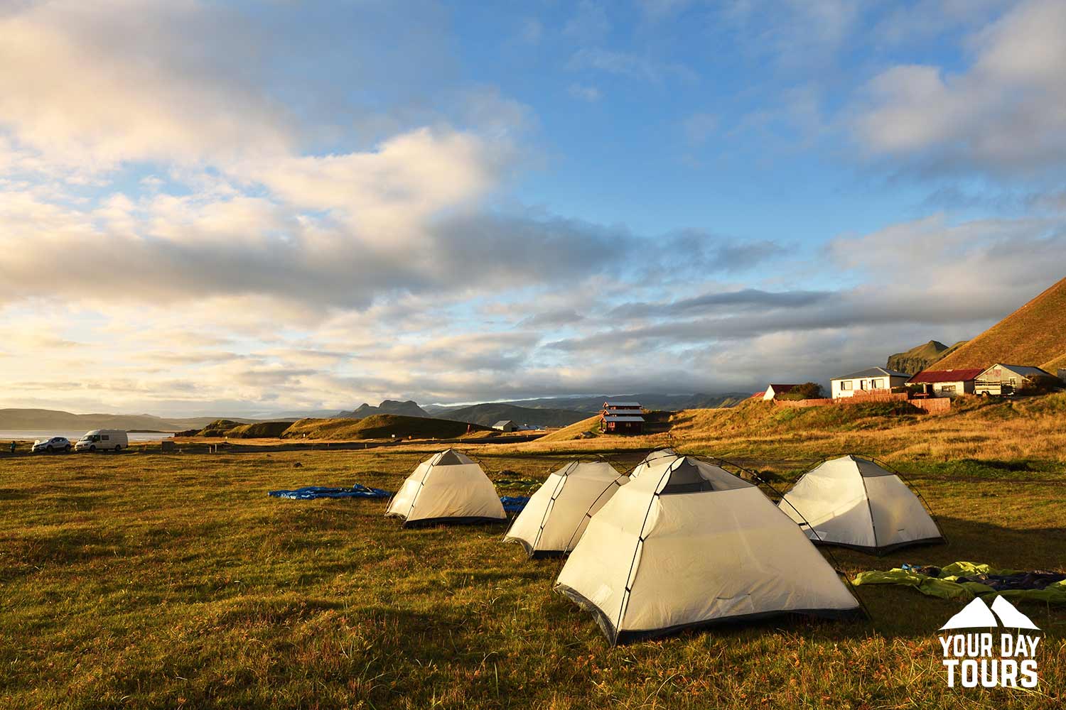 four white tents on the campsite 