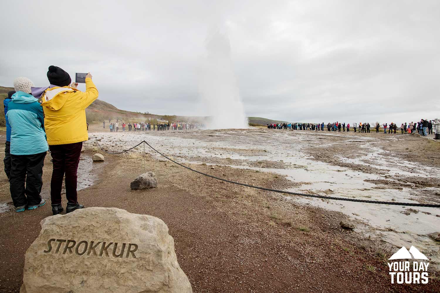 tourists taking photos of  strokkur geysir