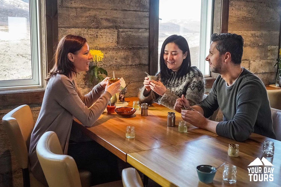 happy friends eating in a restaurant in iceland