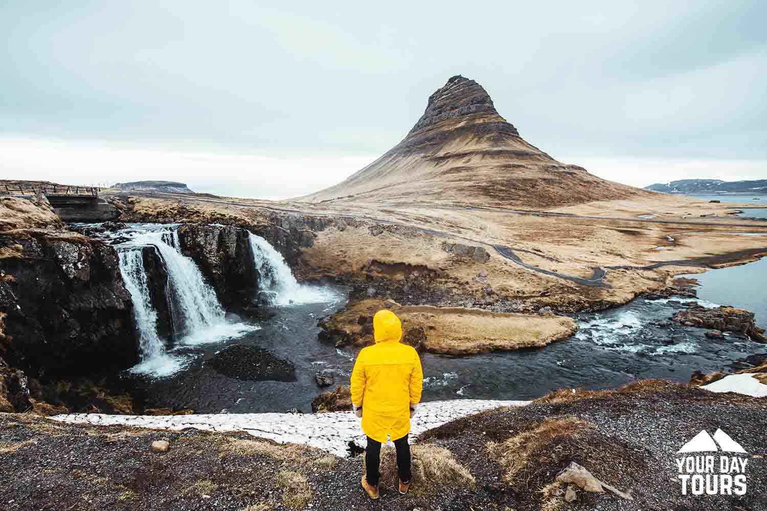 hiker with yellow raincoat sightseeing kirkjufell