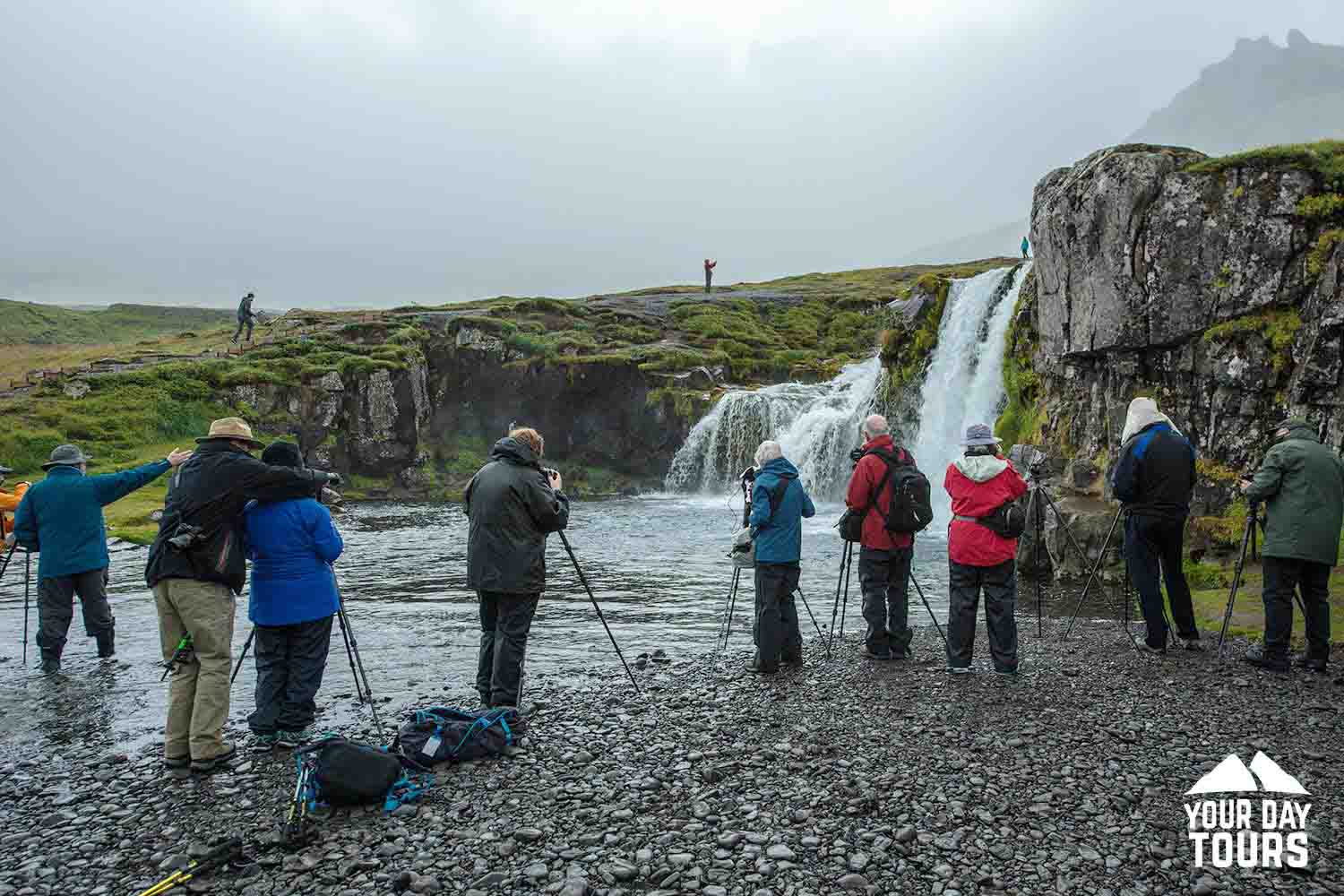 group of people near waterfall in iceland