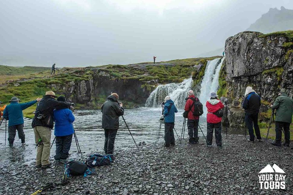 group of people near waterfall in iceland