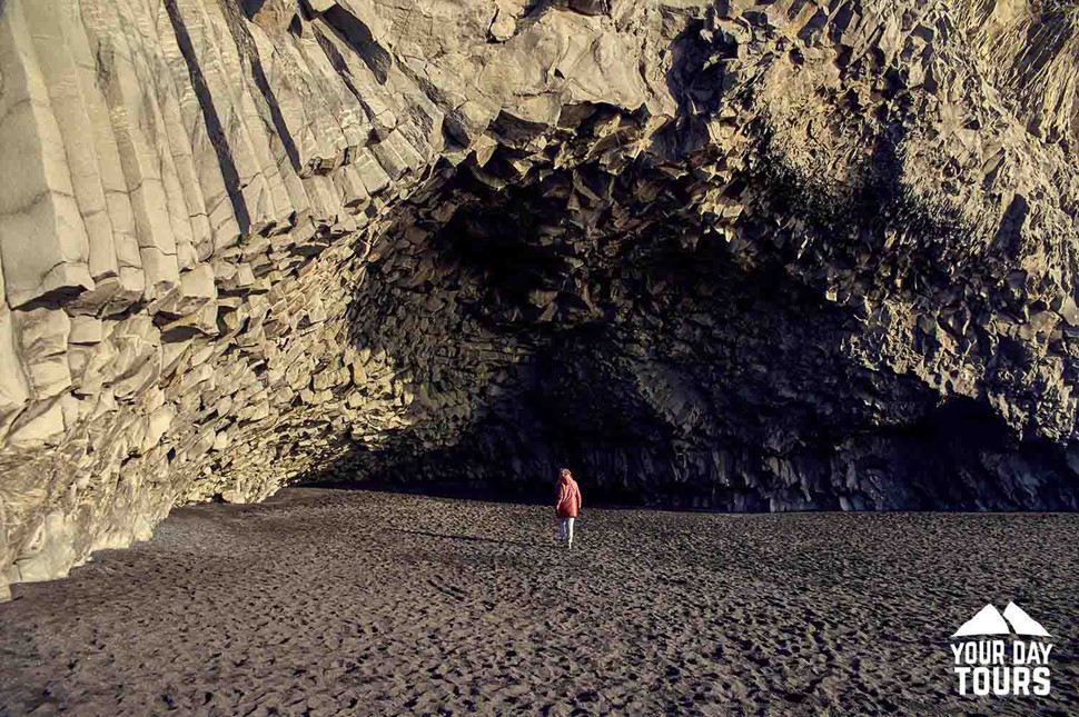 person in a cave at reynisfjara black sand beach
