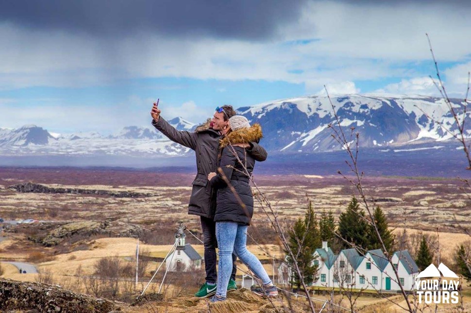 two people taking a picture in thingvellir