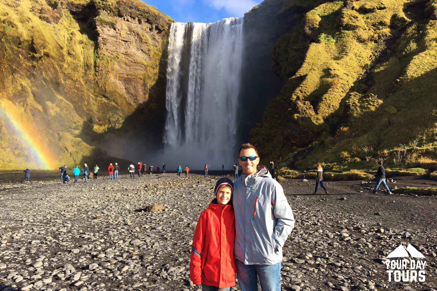 happy father and son posing near skogafoss