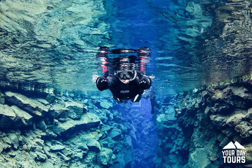 one person snorkeling between two continental plates