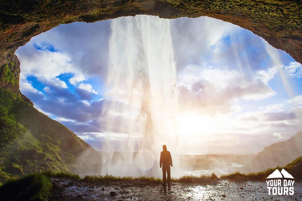 person behind seljalandsfoss waterfall