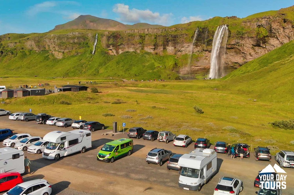 a lot of cars parked near to a waterfall
