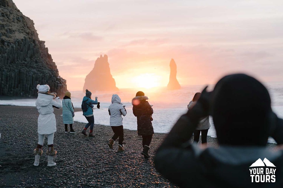 people taking pictures at reynisfjara black sand beach 