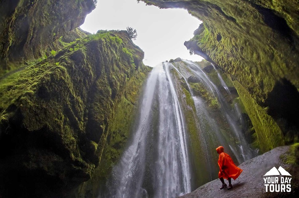 woman in a red raincoat next to gljufrabui 