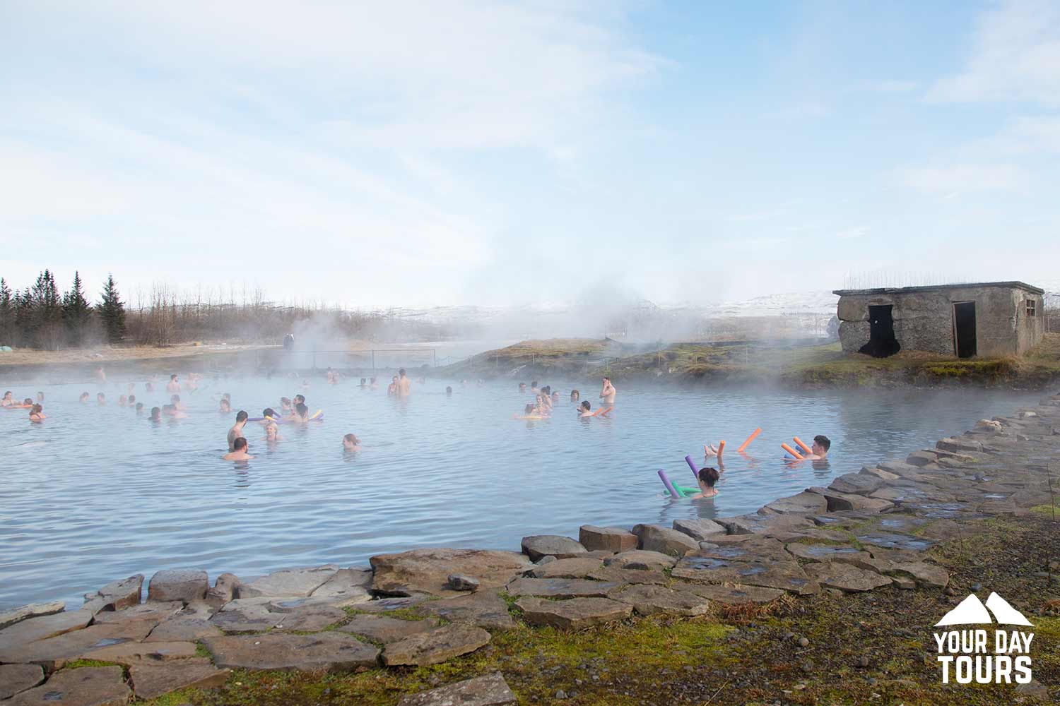 people swimming at secret lagoon in iceland