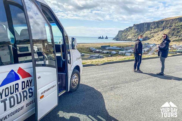 two people and a white bus in iceland 