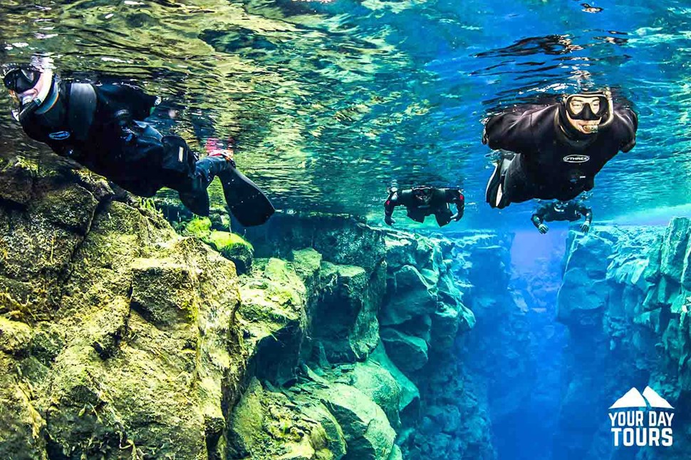 three people snorkeling in silfra