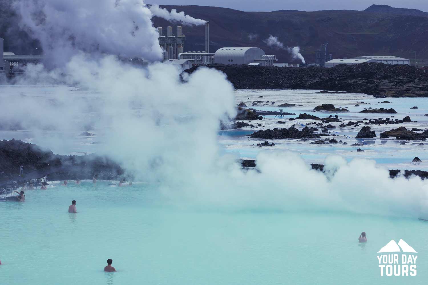 three people bathing in blue lagoon 
