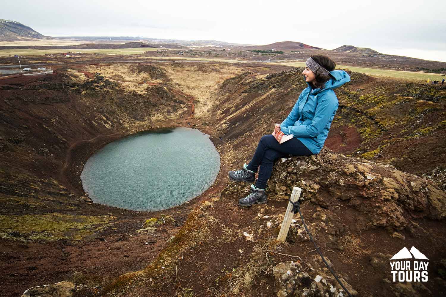 Woman Sitting by Kerid Crater in Iceland